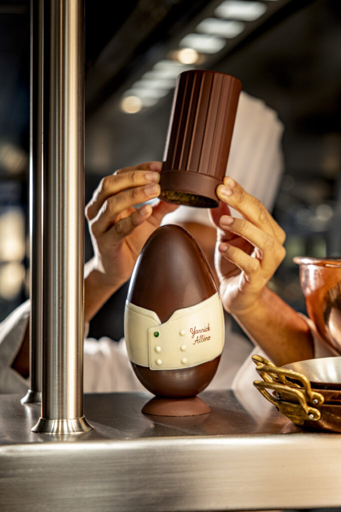 Yannick Alléno — L’Esprit du Chef
Un œuf au design ludique, inspiré de l’univers du chef, où le chocolat intense rencontre le croquant de la pistache. Une création à la fois gourmande et identitaire.